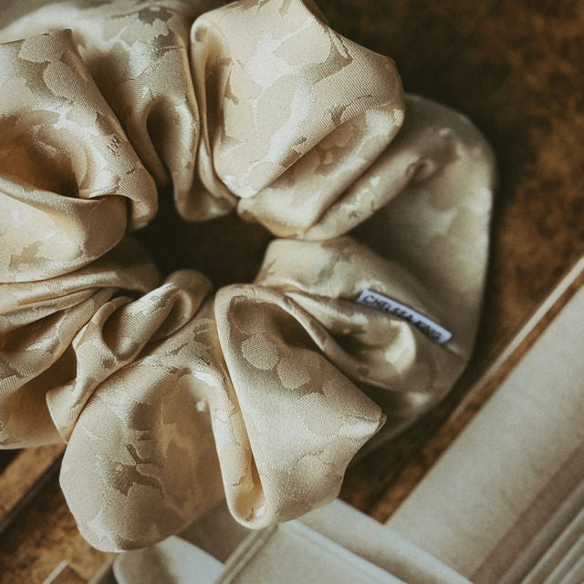 Beige scrunchie on a wooden surface