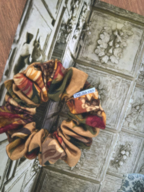 floral jacquard scrunchie with a label on a textured surface